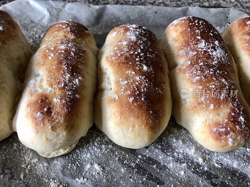 新烤的，自制的白面包桥卷撒上白面粉，向上看手指卷