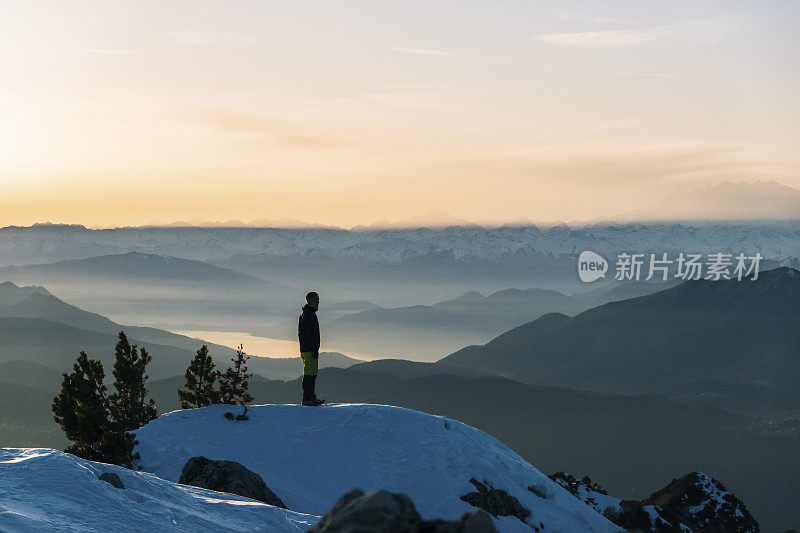 黎明时分，一名越野跑者向外眺望积雪的山脊