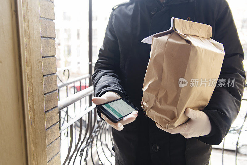 戴着手套在门口送食物的人。