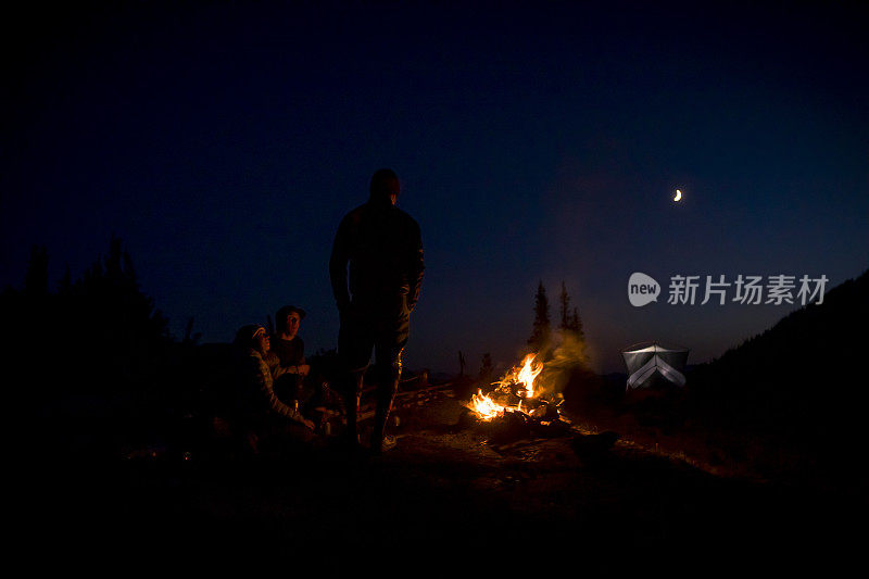 朋友们在晚上露营的时候围着火。