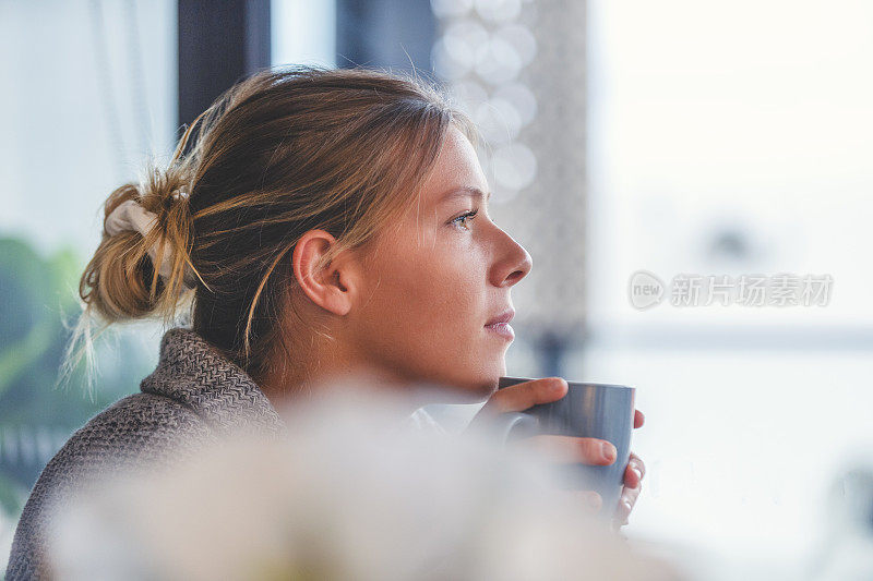 一个女人的肖像，坐在窗前看着。