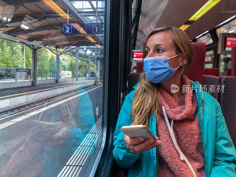 2019冠状病毒病大流行期间，戴着医用口罩在瑞士乘坐火车的年轻女性