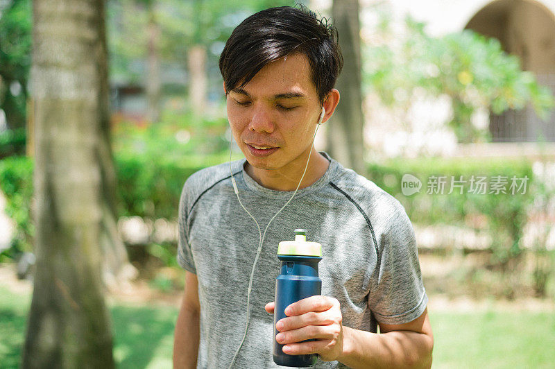 年轻的亚洲跑步者正在休息和喝水