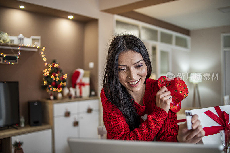 女人用信用卡在家里买新年的礼物-圣诞购物-一个年轻女人在网上买礼物的特写