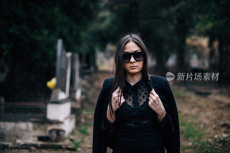 一个年轻的女人穿过墓地