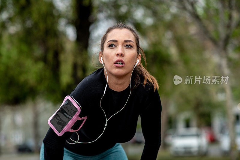 这位活跃的年轻女士在开始慢跑之前要休息一小会儿。