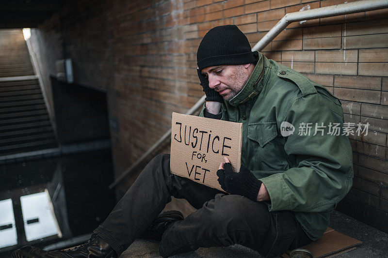 一名退伍军人拿着一个写着“正义为兽医”的标语乞讨