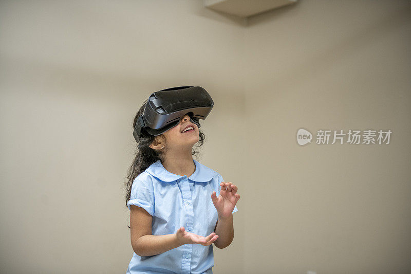 戴着虚拟现实头盔的年轻女孩