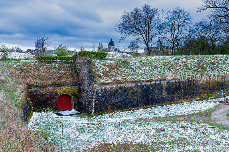 4月，马斯特里赫特的一个公园里，古老的防御工事被罕见的大雪覆盖，背景是天主教大教堂的塔楼
