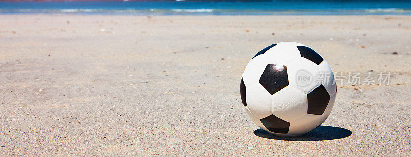 在沙滩上踢足球，准备享受海边的乐趣