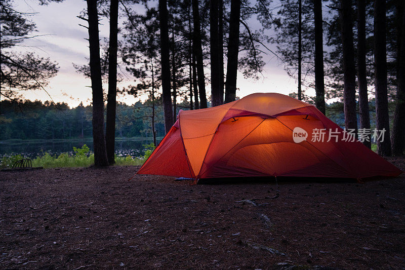黄昏时在湖边露营地搭帐篷