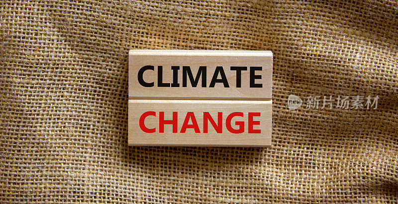 气候变化的象征。美丽的帆布背景上印有“气候变化”字样的木块。商业、生态和气候变化的概念。副本的空间。