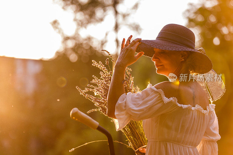 成熟的女人戴着太阳帽享受夏日温暖的阳光