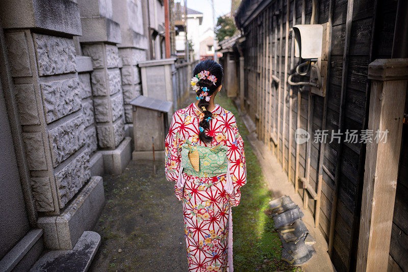 身穿和服的少女走在狭窄的巷子里