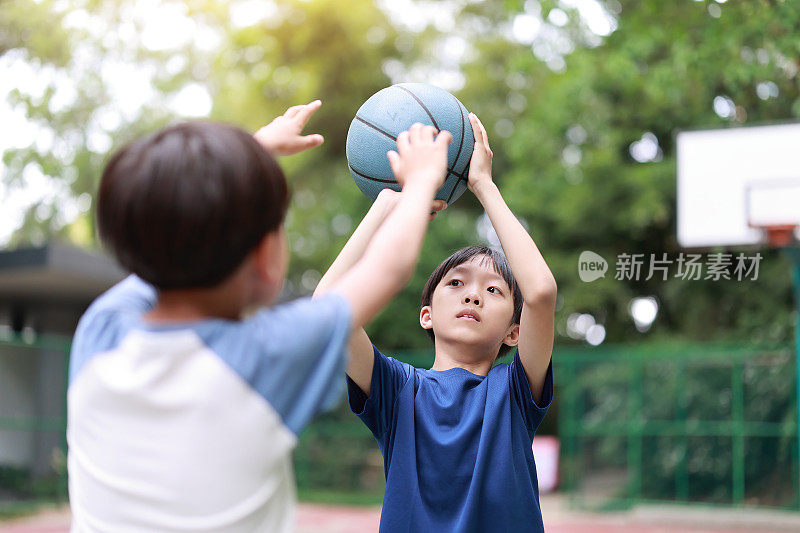 两个男孩在外面打篮球