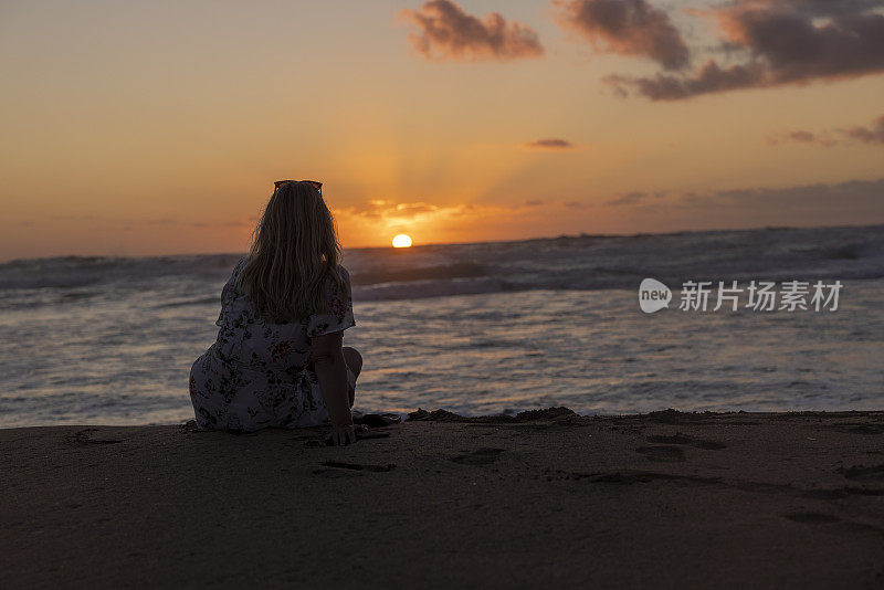 意大利撒丁岛，夕阳西下的海滩上孤独的女人。