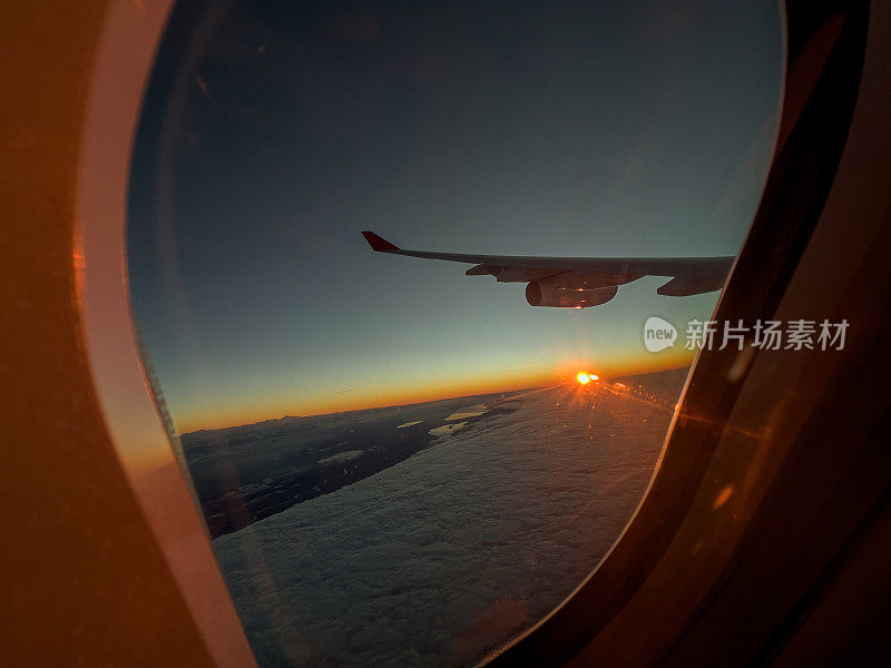 从飞机窗口往外看，美丽的日出在空中