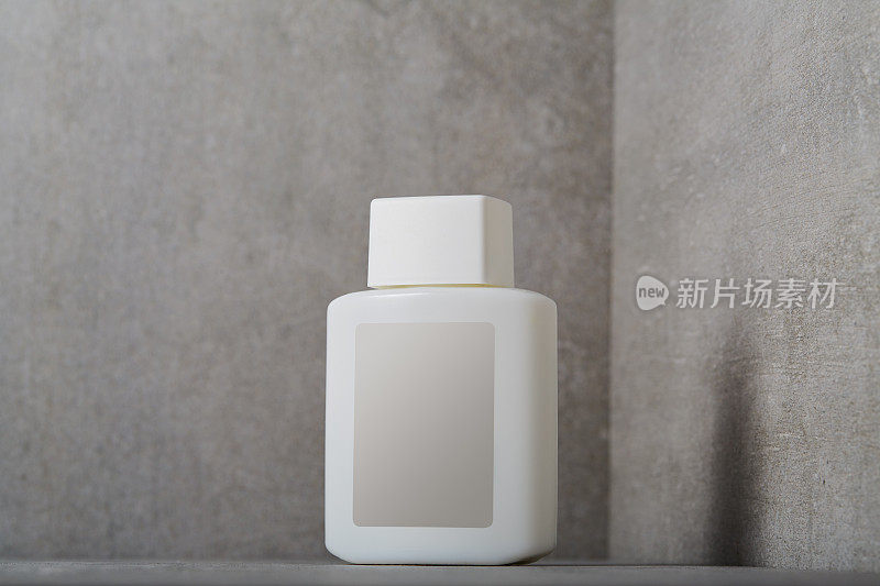 面部或身体护理化妆品瓶子，混凝土背景上有空白标签