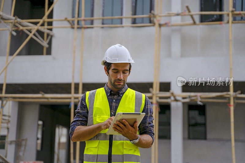 蓝领工人在建筑工地与同事一起工作。