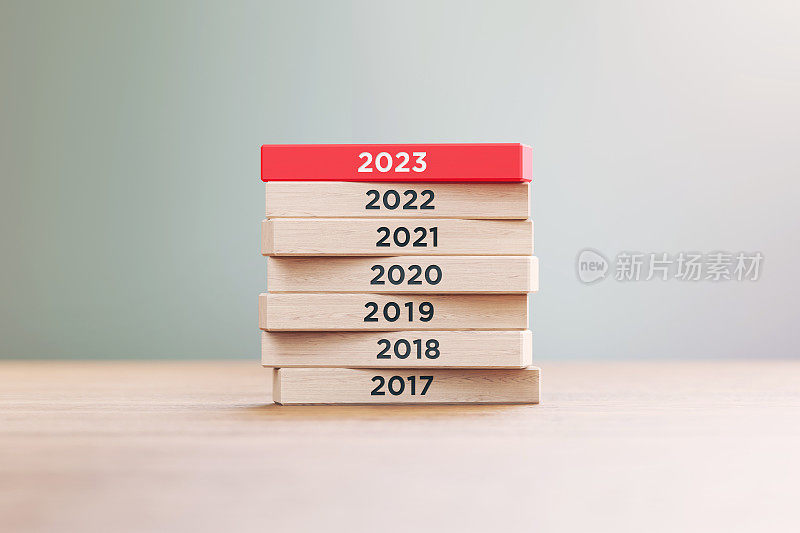 从2017年到2023年写木块坐在木表面前一个散焦背景