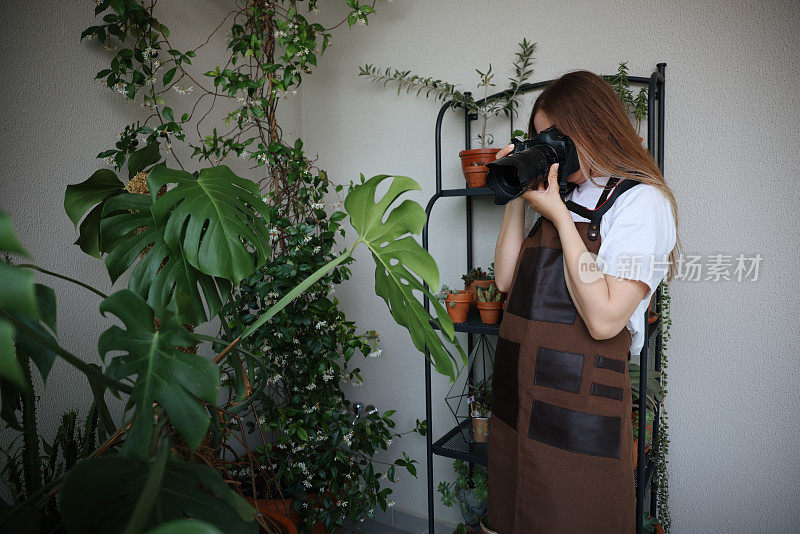 女摄影师用相机给植物拍照。