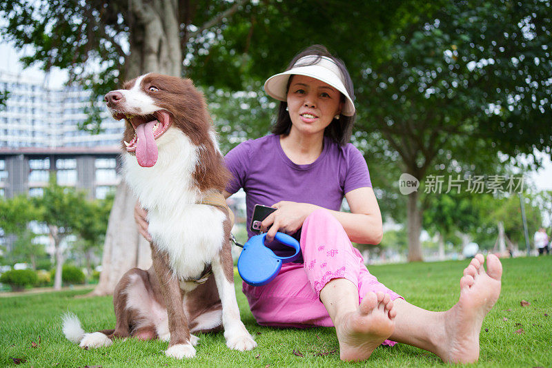 草地上带着宠物狗的女人