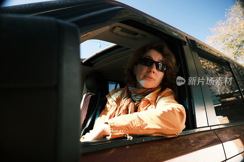 一名妇女坐在一辆家用汽车的驾驶座上