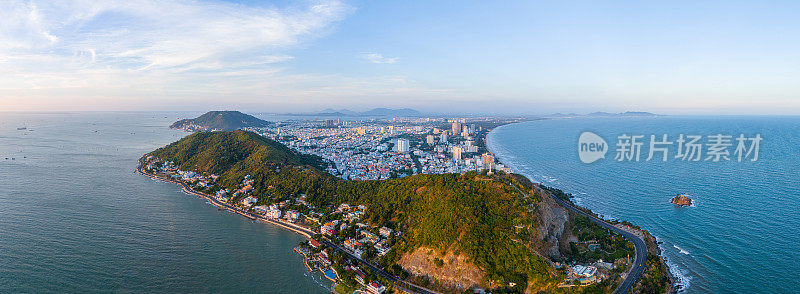 从上面俯瞰云头海岸全景，海浪、海岸线、街道、椰子树、越南Nho山后面的基督国王雕像