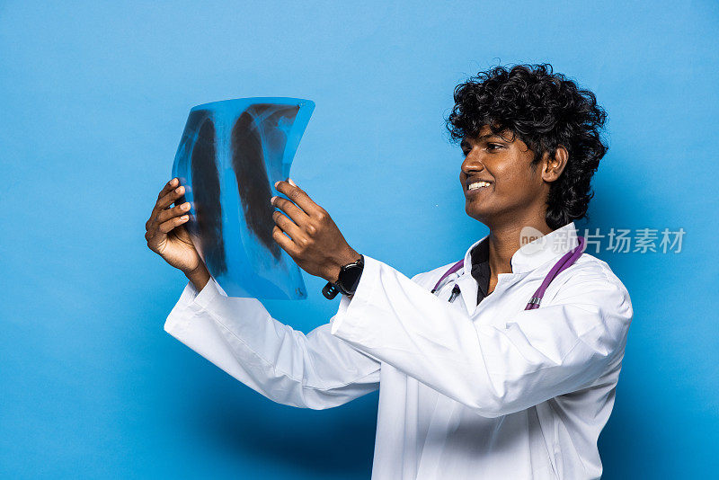 穿着蓝色制服的印度医生正在看脊柱的x光扫描图像