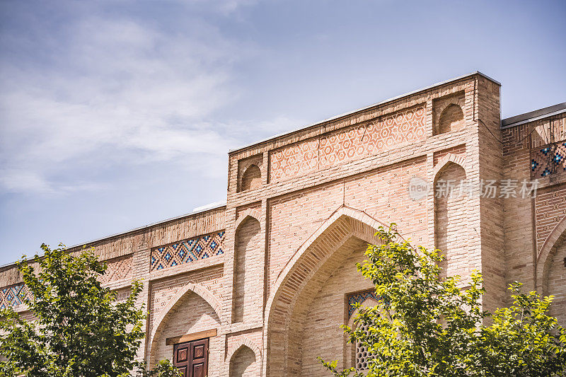 乌兹别克布哈拉古城的马赛克砖砌伊斯兰学校的立面元素，东方风格的建筑，带有图案和装饰的清真寺立面