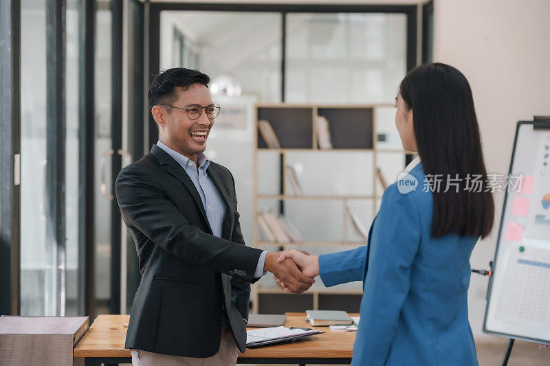 两个专业的亚洲商业同事在会议上握手。