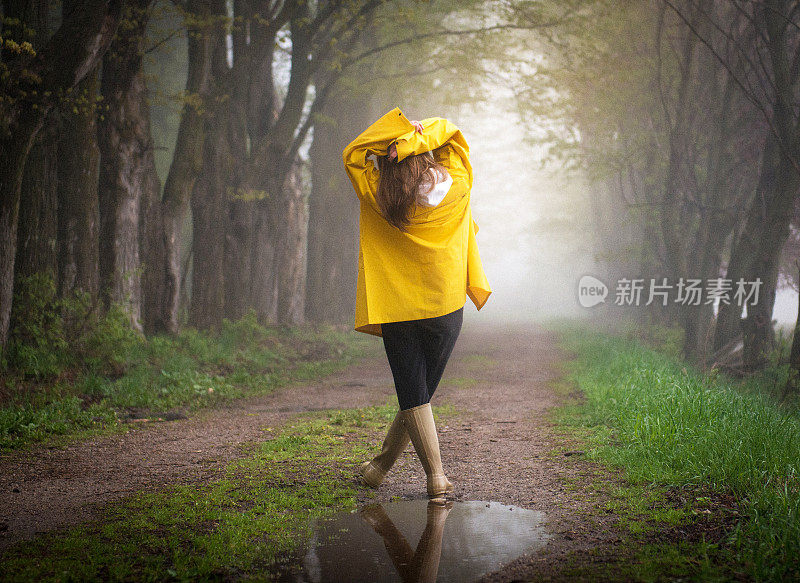 一位穿着雨衣的女士在户外享受宁静的时光。