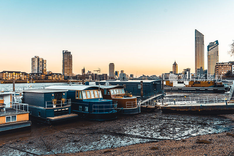 泰晤士河边的旧船和伦敦切尔西的现代建筑