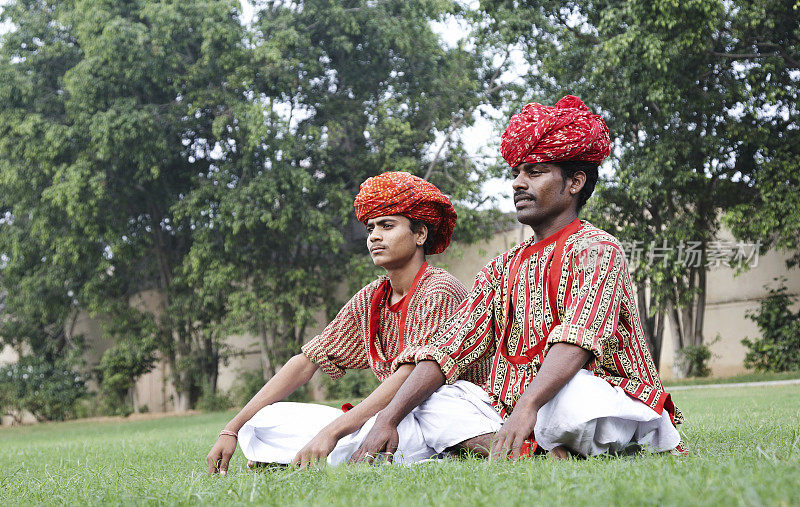 两个印度少年一起在草坪上冥想