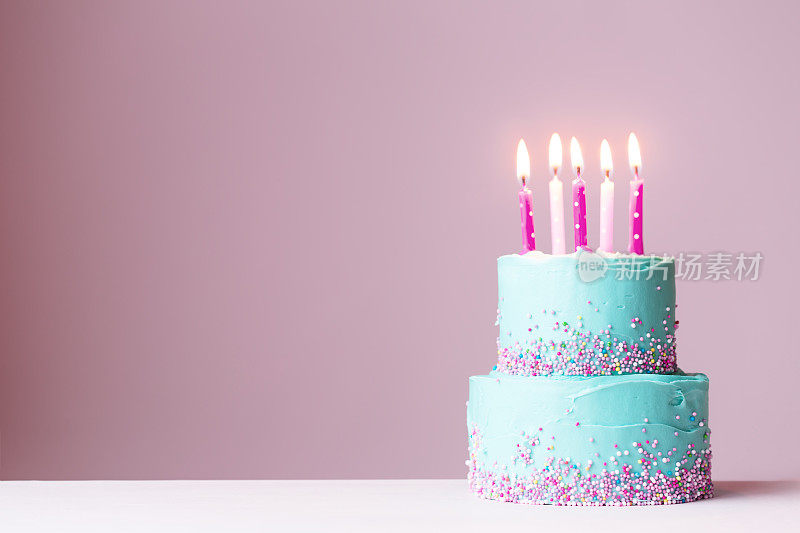 插着粉红色蜡烛的生日蛋糕