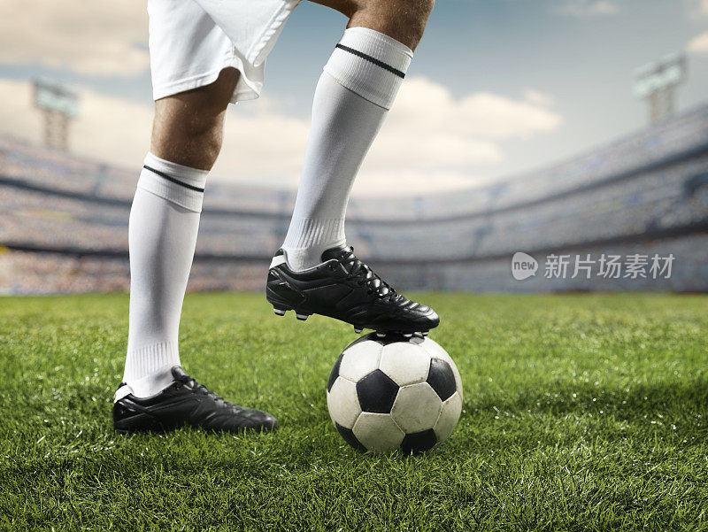 足球运动员的腿在足球上