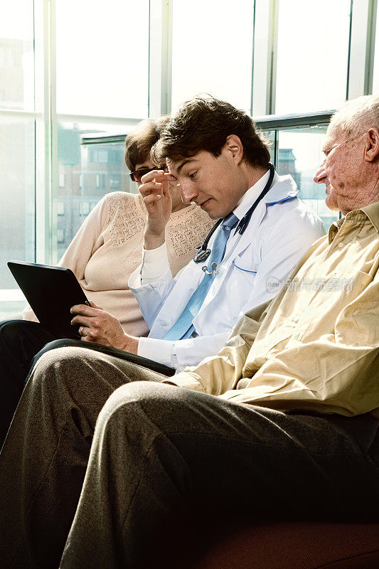 医生在平板电脑上给老两口病人展示体检