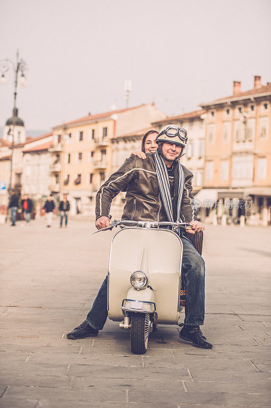 在意大利，一对老式夫妇骑着Vespa摩托车