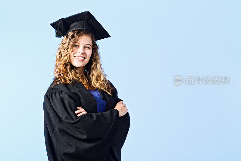 凯旋的年轻女毕业生戴着学士学位帽和学位袍