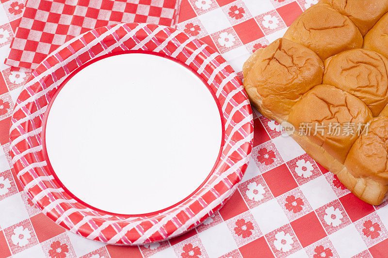 面包卷，盘子放在野餐桌上。