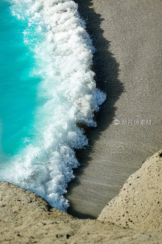 从上面俯瞰热带海滩，碧绿的海浪溅起水花