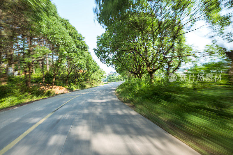 在阳光明媚的日子里，乡间小路上有绿油油的草地