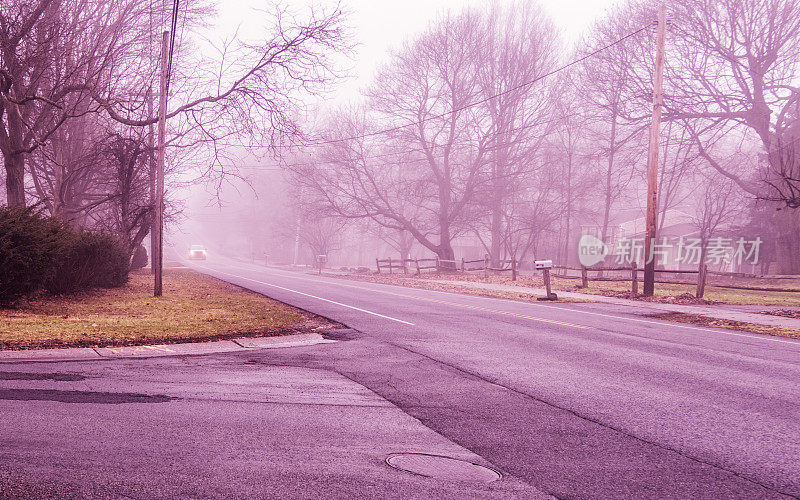 小货车的前灯接近有雾的冬天的早晨乡村道路十字路口