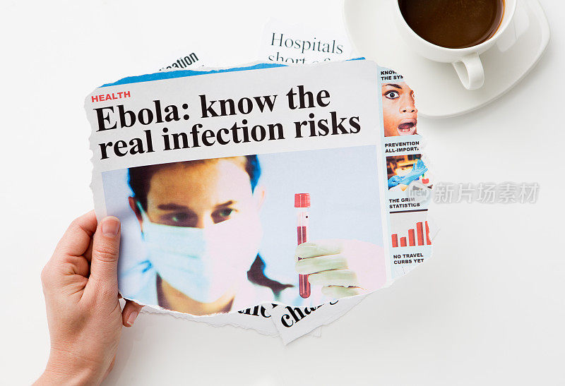 手握一份标题警告埃博拉感染风险的报纸