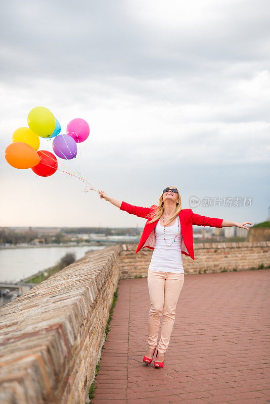 带着气球微笑的年轻女子