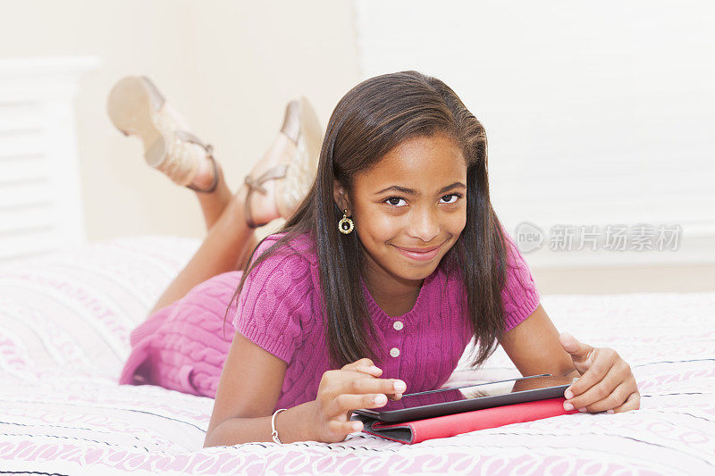 非裔美国女孩在卧室里用平板电脑
