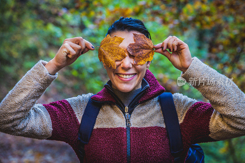 用树叶遮住脸的女人