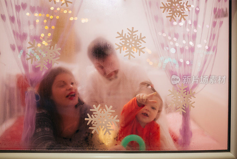 一家人在圣诞夜的窗户后面