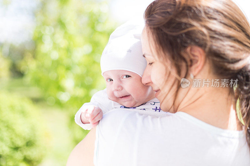 妈妈在公园里拥抱她的小女儿