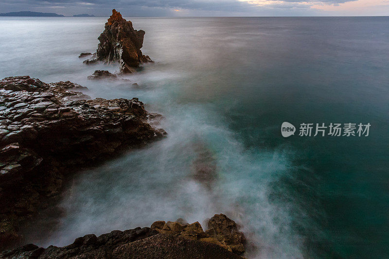 黄昏时的岩石和海浪